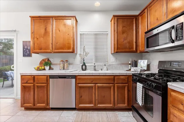 a kitchen with stainless steel appliances granite countertop a stove a sink and a microwave