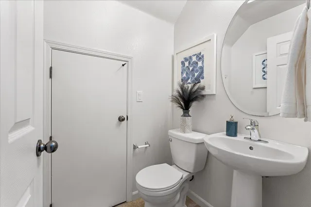 a bathroom with a toilet a sink and mirror