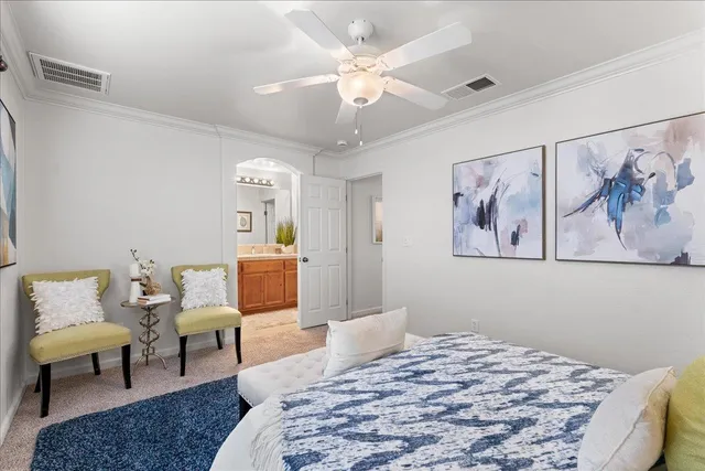 a bedroom with a bed a couch and a chandelier