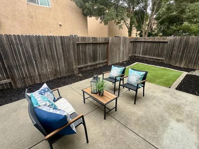 a backyard of a house with barbeque oven table and chairs