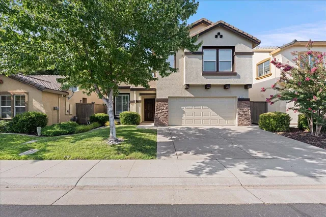 a front view of a house with a yard and garage
