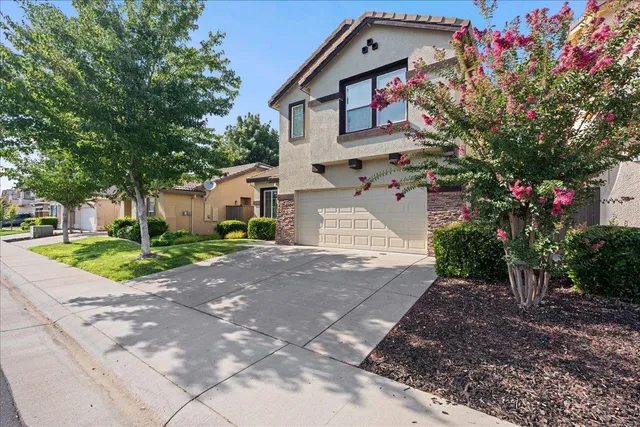 a front view of a house with a yard and a garage