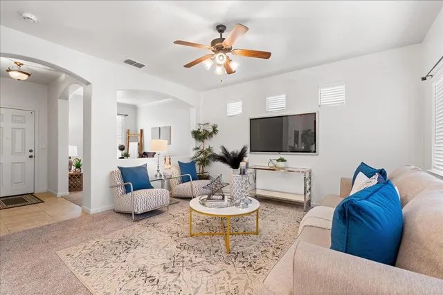 a living room with furniture a flat screen tv and a window