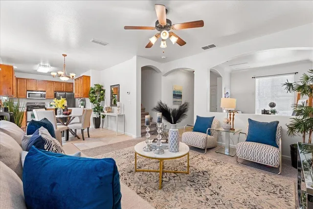 a living room with furniture kitchen view and a chandelier