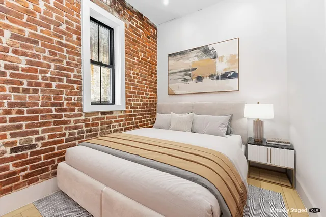 a bedroom with a bed and a painting on the wall