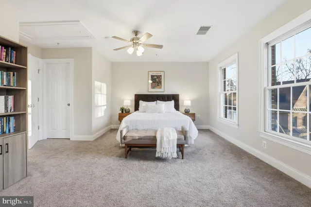 a spacious bedroom with a large bed and a chandelier