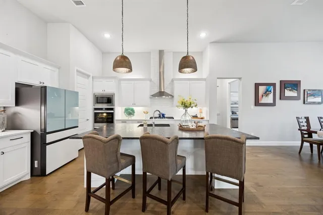 a room with stainless steel appliances kitchen island a table and chairs in it