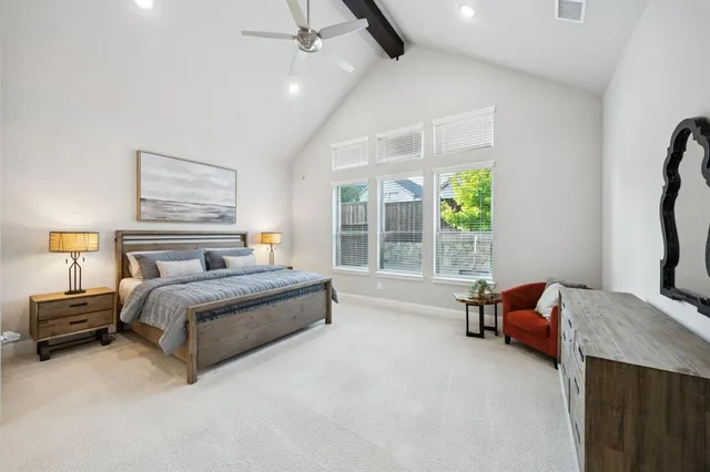 a spacious bedroom with a bed and a chandelier