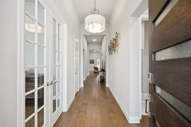 a view of a hallway with wooden floor and entryway