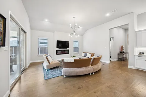 a living room with furniture a flat screen tv and a large window