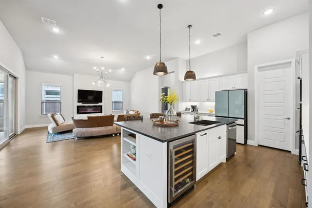 a kitchen with stainless steel appliances granite countertop a stove and a wooden floors
