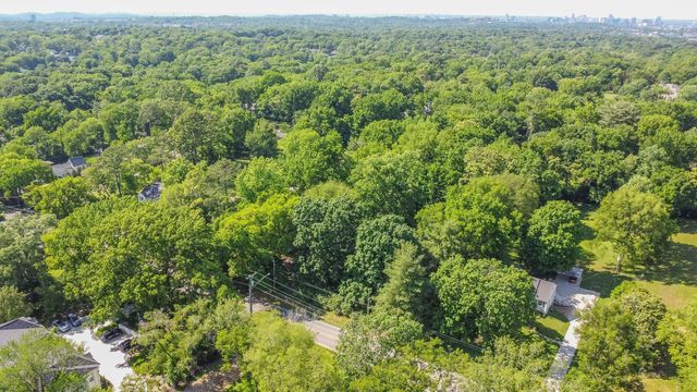 an aerial view of residential houses with outdoor space and trees