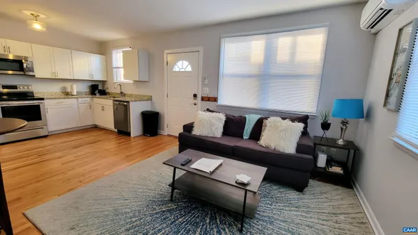 a living room with furniture and a wooden floor