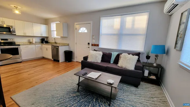 a living room with furniture and a wooden floor