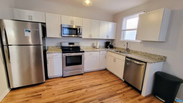 a kitchen with a refrigerator sink and wooden floor