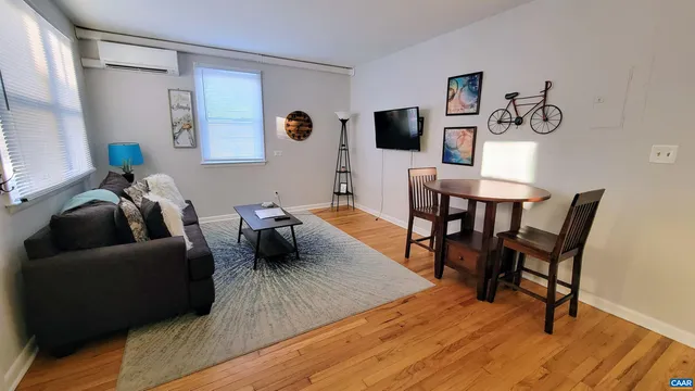 a living room with furniture and a wooden floor