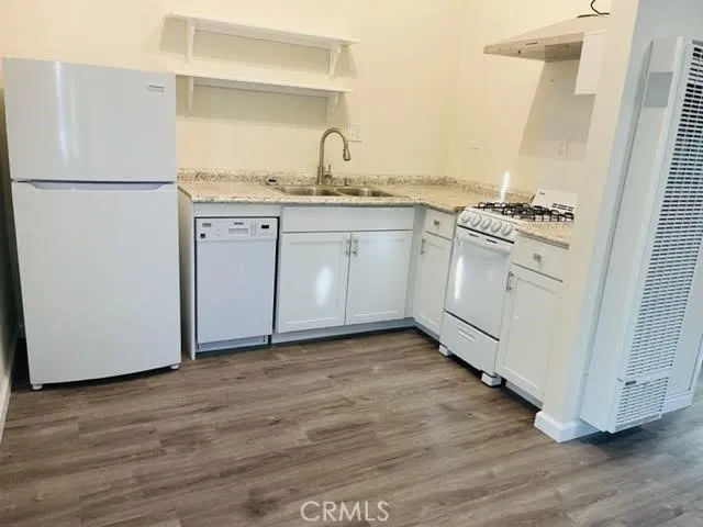 a kitchen with white cabinets and white appliances