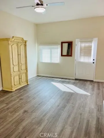 an empty room with wooden floor and door