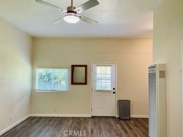 an empty room with windows and ceiling fan