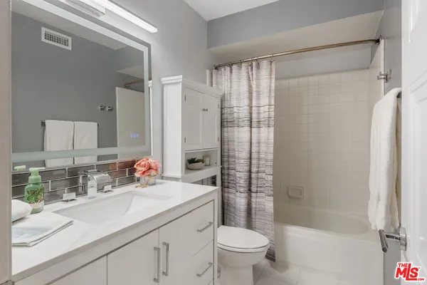 a bathroom with a shower sink vanity mirror and toilet