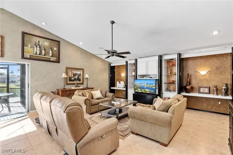 a living room with furniture a chandelier and a flat screen tv