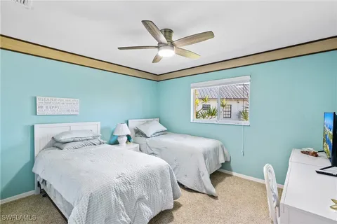a bedroom with two beds and ceiling fan
