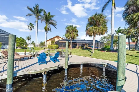 a view of a patio with table and chairs potted plants and palm tree