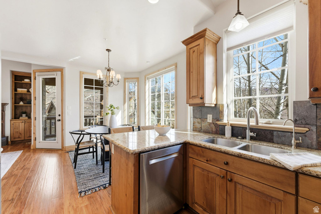 3026 Lower Saddleback Road Park City, UT 84098 - Photo 16 of 71 Kitchen with pendant lighting, dishwasher, brown cabinetry, and light stone counters