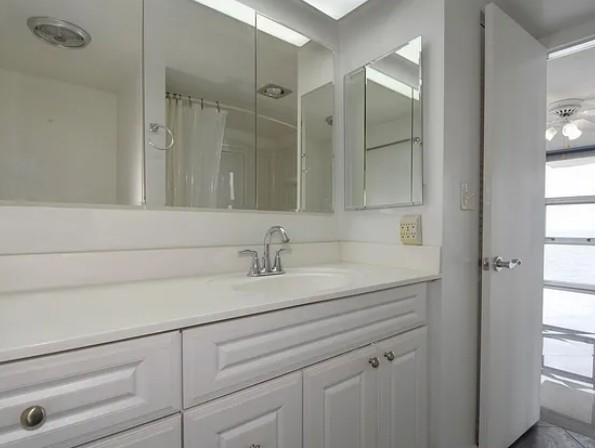 531 North Ocean Boulevard, Unit 1911 Pompano Beach, FL 33062 - Photo 25 of 34 a bathroom with a sink and a mirror