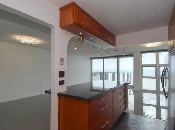 a kitchen with granite countertop wooden cabinets and a stove top oven