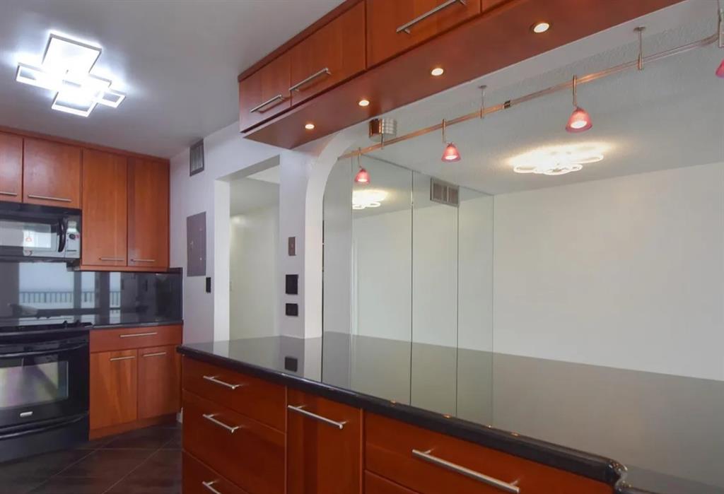 531 North Ocean Boulevard, Unit 1911 Pompano Beach, FL 33062 - Photo 7 of 34 a kitchen with kitchen island a counter space a sink and stainless steel appliances