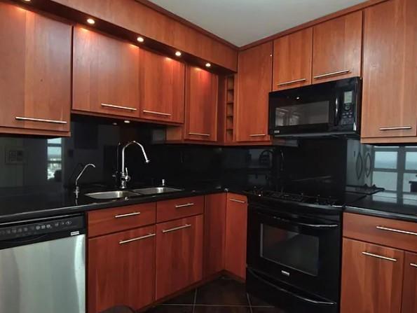 531 North Ocean Boulevard, Unit 1911 Pompano Beach, FL 33062 - Photo 8 of 34 a kitchen with granite countertop wooden cabinets and a stove top oven