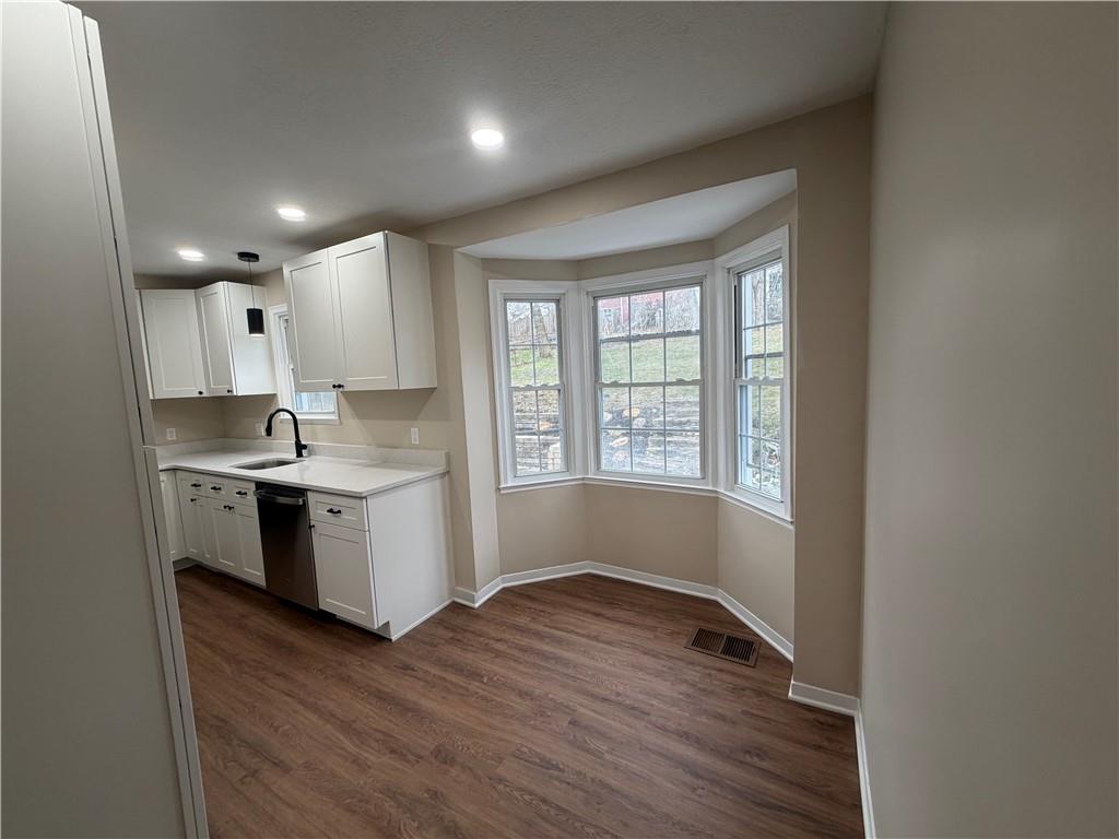 315 Caperton Street Pittsburgh, PA 15210 - Photo 12 of 16 a kitchen with granite countertop white cabinets and wooden floor