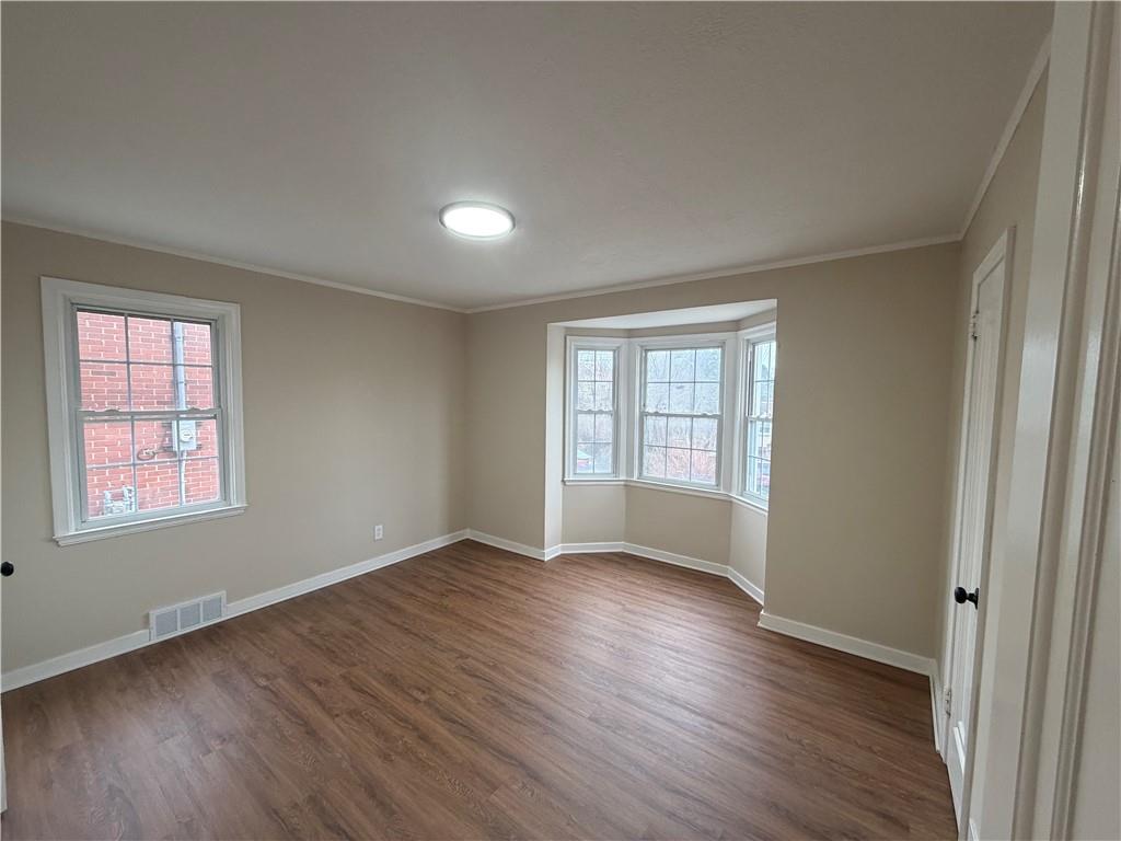 315 Caperton Street Pittsburgh, PA 15210 - Photo 6 of 16 an empty room with wooden floor and windows