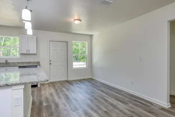 an empty room with wooden floor and a window
