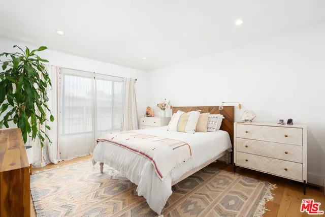 a bedroom with a large bed and a potted plant