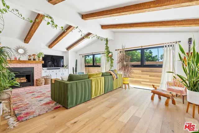 a living room with furniture a flat screen tv and a floor to ceiling window