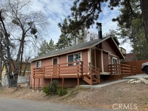 a view of a house with a yard chairs and a large tree