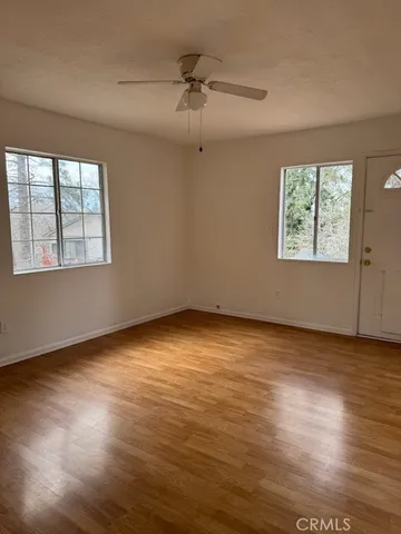 an empty room with wooden floor and windows