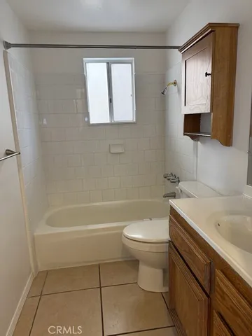 a bathroom with a sink a toilet a mirror and bathtub