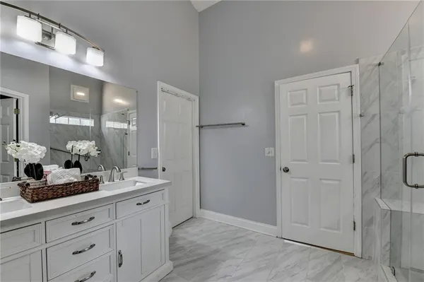 a bathroom with a double vanity sink and mirror with shower