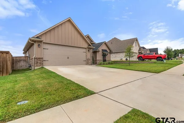 a view of a big house with a big yard and large trees