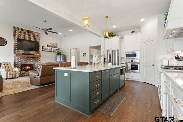 a large kitchen with stainless steel appliances kitchen island granite countertop a large counter top space a sink stainless steel appliances and cabinets