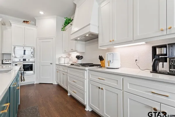 a kitchen with granite countertop white cabinets and white appliances