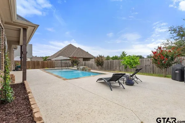 a view of a patio with a table and chairs under an umbrella