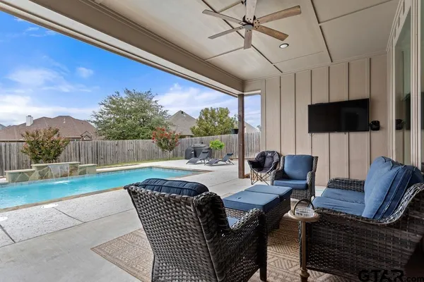 a living room with patio furniture and a flat screen tv