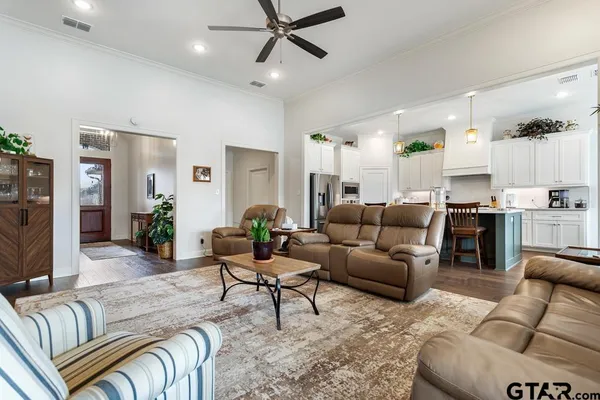 a living room with furniture and a view of kitchen