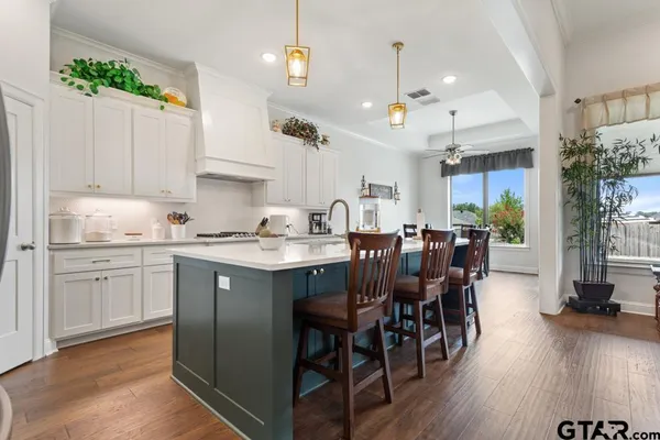 a kitchen with granite countertop a table chairs sink and cabinets