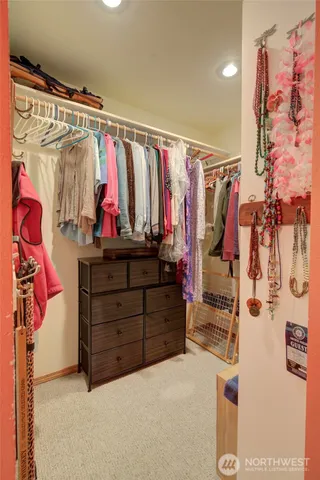 a view of walk in closet with clothes