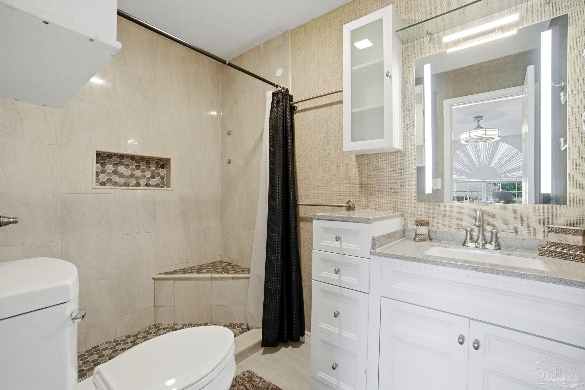 1805 West 10 Mile Road Pensacola, FL 32534 - Photo 23 of 61 a bathroom with a toilet a sink and mirror